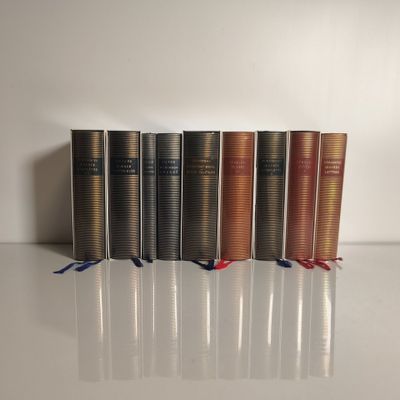 plusieurs livres sont alignés sur une surface blanche