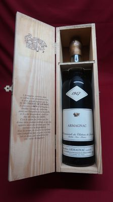 a bottle of wine in a wooden box on a red cloth