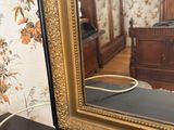 a mirror that is sitting on a table in front of a bed