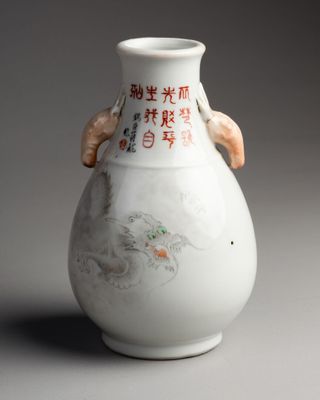 a white vase with asian writing on it on a gray surface