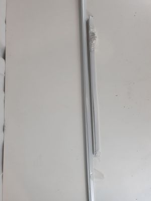 un réfrigérateur blanc avec une porte en métal sur laquelle est posé un stylo