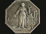 un médaillon en argent représentant une femme tenant une fleur