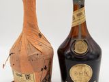 two bottles of liquor sitting next to each other on a white surface