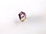 une image représentant une bague ornée d'une pierre violette sur un fond blanc