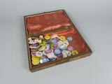 a wooden box with buttons in it on a white surface