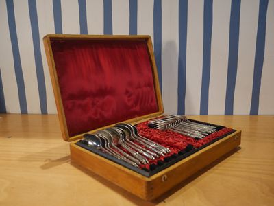 une boîte en bois contenant de l'argenterie sur une table