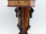 a small wooden table with carvings on it