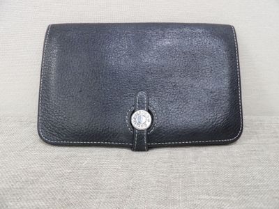 leather wallet with a button on the front of it sitting on a couch