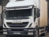 deux camions garés dans un entrepôt, dont l'un se trouve à l'arrière de l'autre