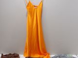 une robe suspendue à un cintre à côté d'une pile de vêtements
