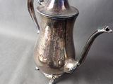 a silver tea pot and a silver teapot on a table