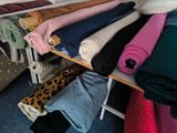 many blankets and blankets on a rack in a room