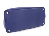 the large blue bag is sitting on a white surface