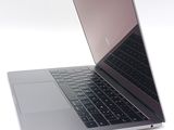 a silver laptop with a black keyboard on a white surface