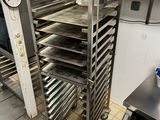 Plusieurs plateaux de nourriture sont posés sur une grille métallique dans une cuisine