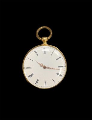 une vieille montre de poche en or avec des chiffres romains et des chiffres romains sur le cadran