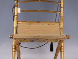 une chaise dorée avec une assise en bois sur fond gris