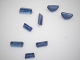 a group of blue glass beads sitting on top of a white surface