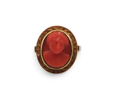 a red coral and gold ring with a woman ' s face
