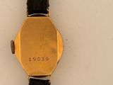 a close up of a watch on a white surface