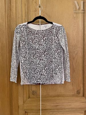 un pull noir et blanc accroché à une porte en bois