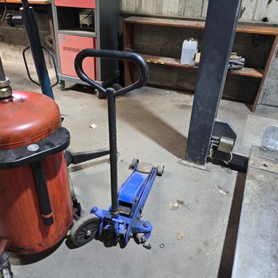 a red fire extinguisor sitting on the floor next to a blue fire hydrant
