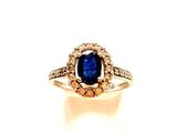 gros plan d'une bague avec une pierre bleue entourée de diamants
