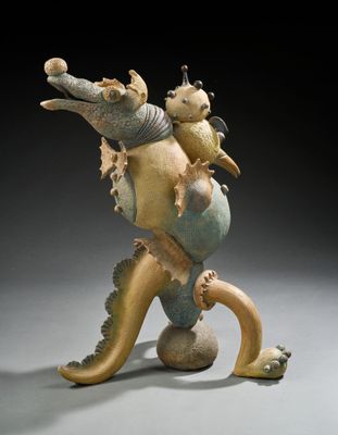 une image représentant une sculpture d'un hippocampe avec un poisson sur le dos
