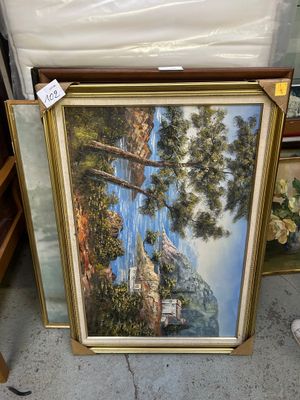 une photo d'un tableau représentant un paysage de montagne, dans un cadre