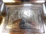 une assiette en argent sur laquelle est représenté un homme