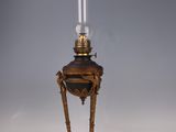 an antique brass table lamp with a candle on top of it