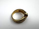 a close up of a gold ring on a white surface