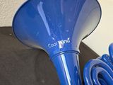 a blue trumpet sitting on top of a black table next to a wall