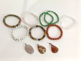 Plusieurs bracelets de différentes couleurs et formes sont disposés sur une surface blanche.