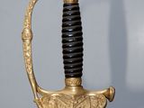 an image of a gold and black sword with a black handle