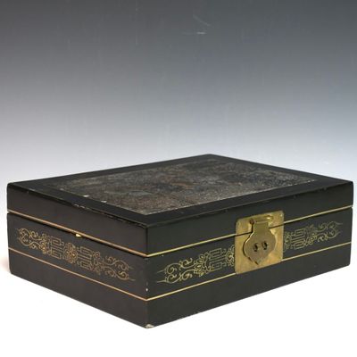 une boîte noire ornée de dorures et dotée d'une serrure sur le couvercle