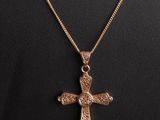 un pendentif en forme de croix en or sur un collier de mannequin