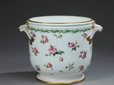 un vase blanc avec des fleurs roses sur une table