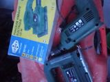 two power tools sitting on top of a red suitcase