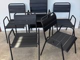 quatre chaises et une table dans une pièce aux murs blancs