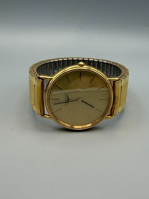 an image of a gold watch on a white surface