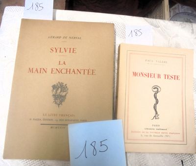 Plusieurs livres sont posés sur une table recouverte d'une nappe blanche.