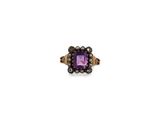 un gros plan d'une bague ornée d'une pierre violette entourée de perles