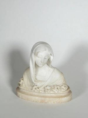 statue d'une femme, la tête voilée, assise sur un rocher