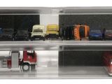 many toy cars in a display case on a white surface