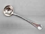 cuillère plaquée argent sur un fond gris, avec une cuillère au milieu de la cuillère