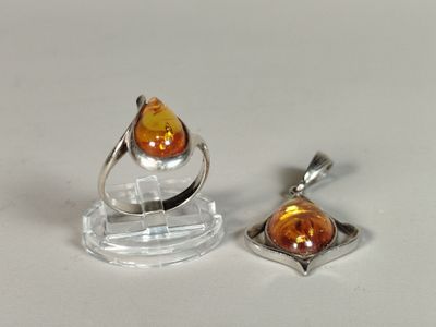two pieces of jewelry that are sitting on a table
