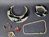 un collier, un bracelet et une bague noirs et blancs posés sur une table