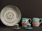 trois tasses, une soucoupe et une assiette posées sur une table