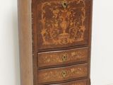 a small wooden chest of drawers with a marble top
